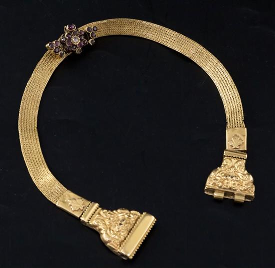 A late Victorian milanese gold choker necklace with repousse clasp and garnet set slide, 34cm.